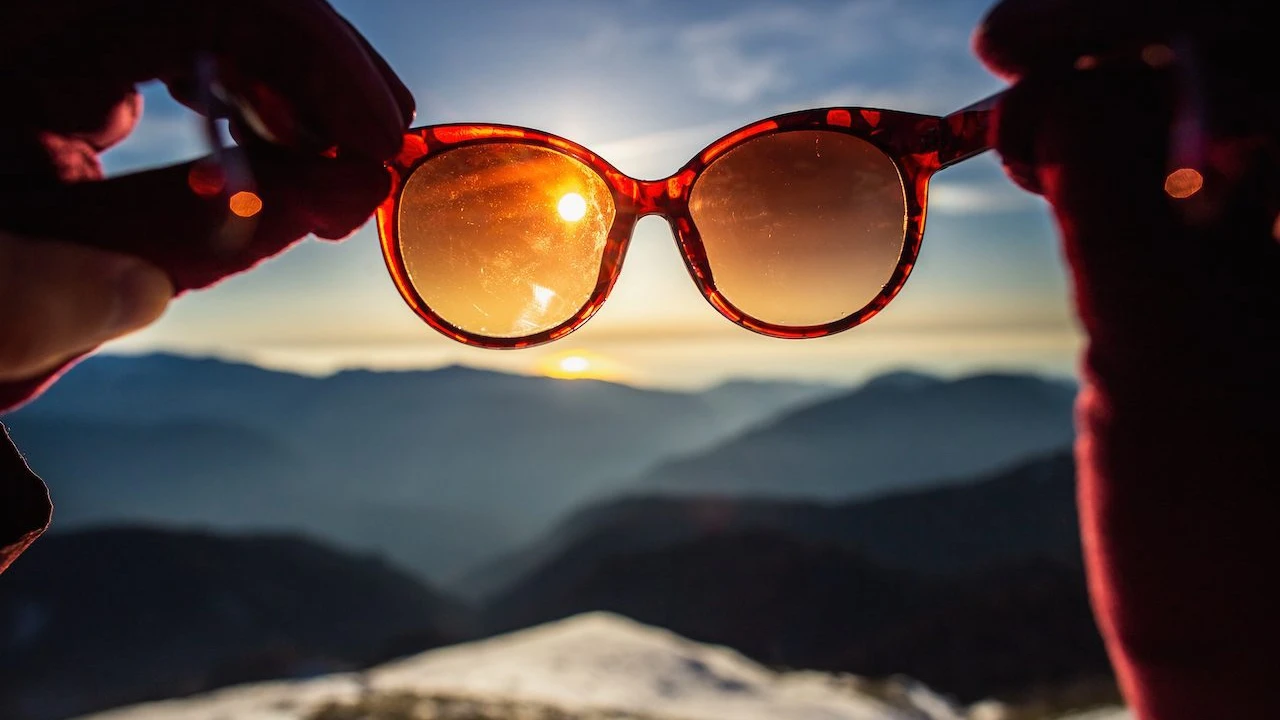 Close up on a plate of mashed potatoes, topped with baked pork chops with cream of mushroom soup, and a side of green beans.